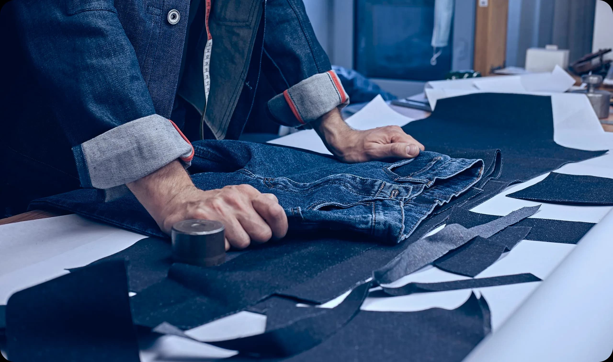 Cutter laying out denim panels on the cutting table